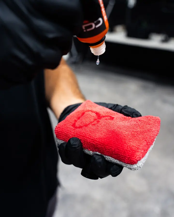 Ceramic coating dripping onto a red applicator pad