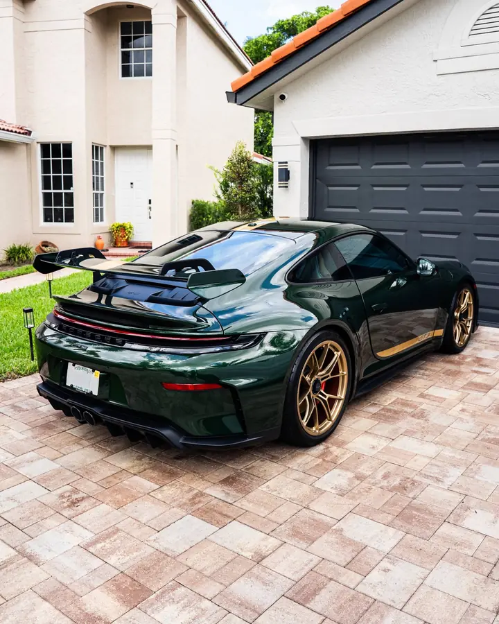 Dark green Porsche 911 GT3 with gold wheels after paint correction