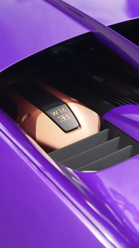 Technicians hand washing a purple Bugatti Chiron Pur Sport in a driveway