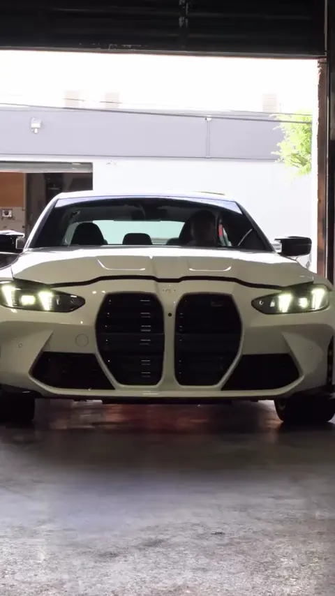 Technicians prepping and applying ceramic coating to a white BMW M3