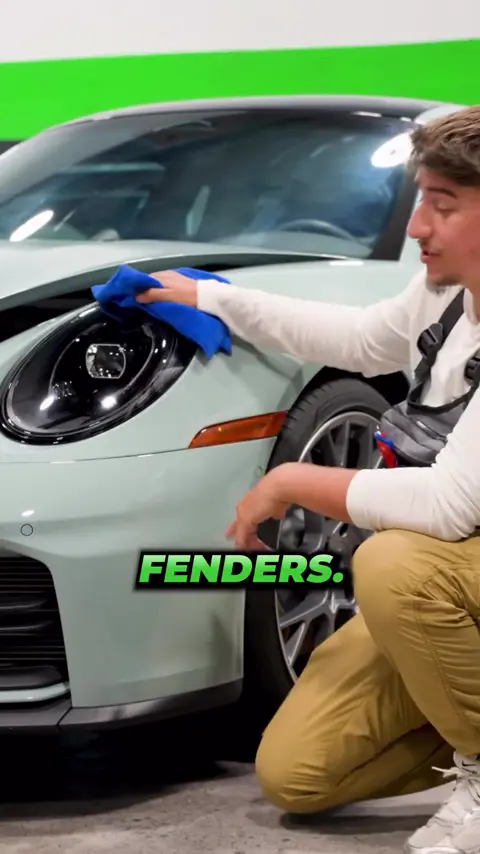 Technician explaining full-front paint protection film on a light blue Porsche 911